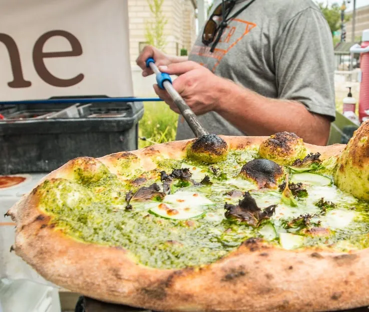 Pizza saliendo del horno de leña
