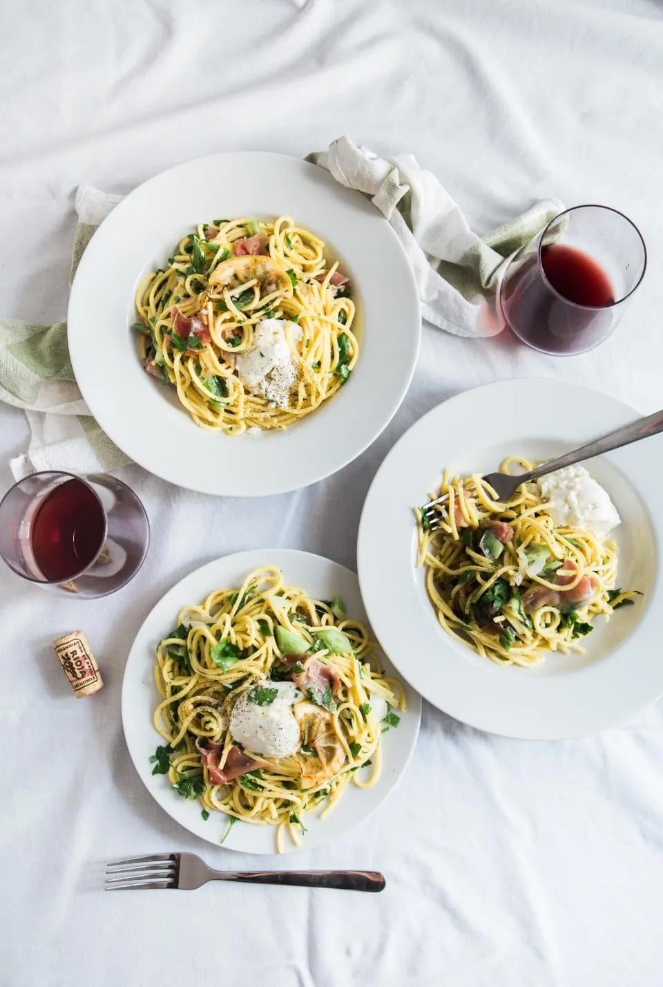 Mesa con pasta y copas de vino